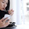 Girl eating while using her phone